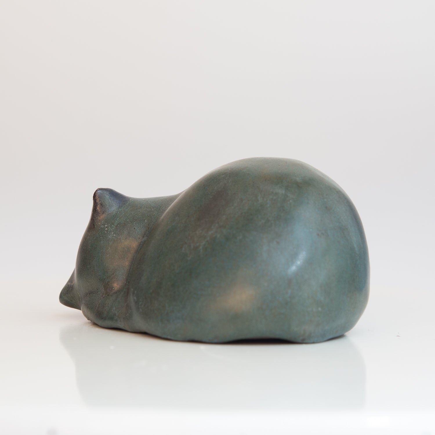 Kleine, zusammengerollte Keramik-Katze in grün