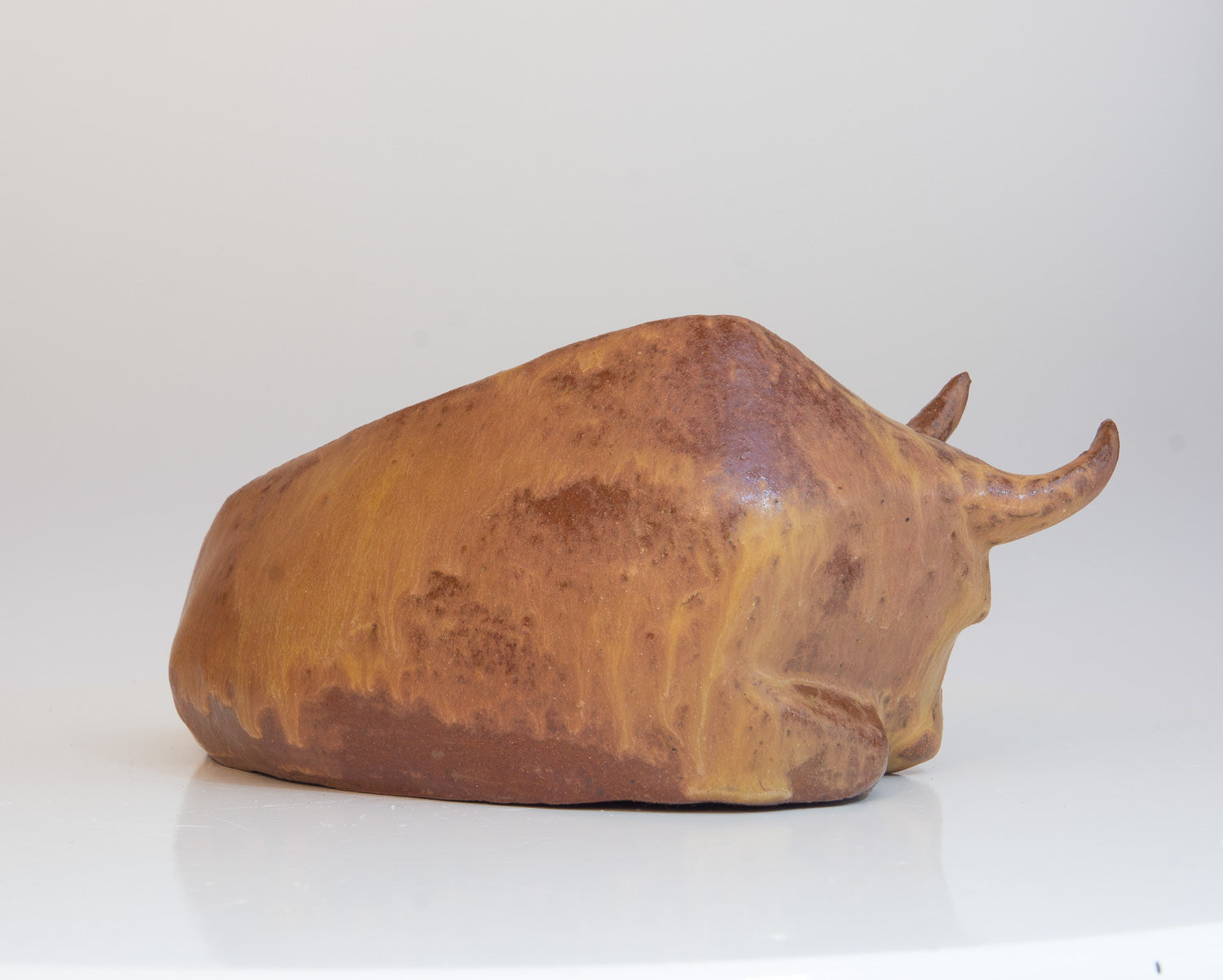 Liegender Stier aus Keramik mit orangebrauner Glasur